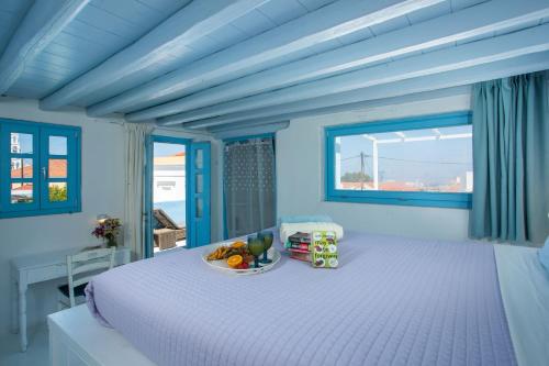 une chambre bleue avec un lit avec un bol de fruits dessus dans l'établissement Mandarin Greek Traditional Home, à Rhodes