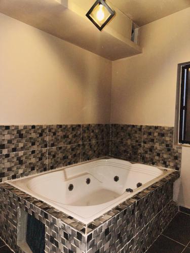 a bath tub in a room with a tiled wall at History Center Hotel in Medellín