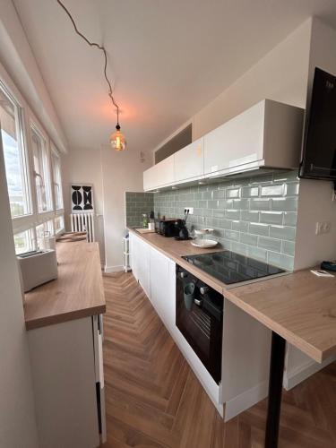 une cuisine avec des armoires blanches et un comptoir dans l'établissement Studio cosy et apaisant, à Metz