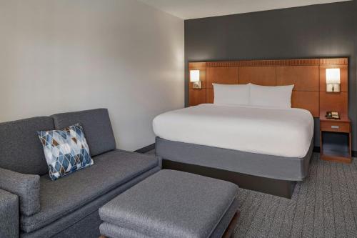 a hotel room with a bed and a couch at Courtyard Anaheim Buena Park in Buena Park