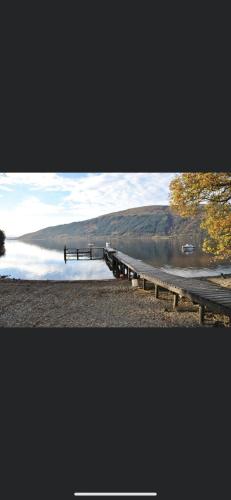 a lake with a dock in the middle of it at Lomond Lodge Rowardennnan in Rowardennan