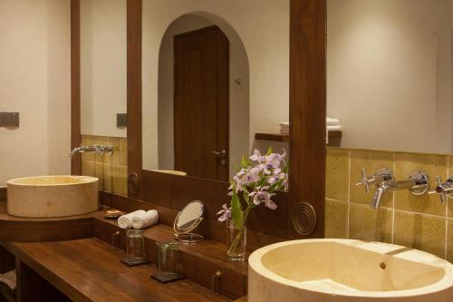 a bathroom with two sinks and a large mirror at Sanctum Inle Resort in Nyaung Shwe