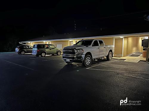 a white truck parked in a parking lot at night at Travel Inn & Suites Flemington in Flemington