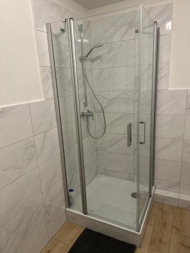 a shower with a glass door in a bathroom at Between in Lübeck