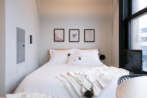 a bedroom with a white bed and a tv at Downtown Spokane Studio Walkable & Secure Stay in Spokane