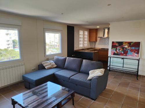 a living room with a blue couch and a table at Seaside Beach-Lounge Alicante in El Campello