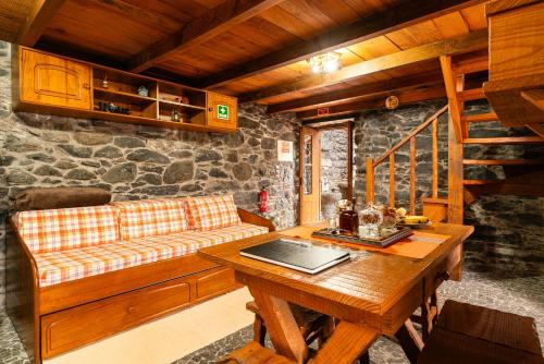 a living room with a couch and a table at King's House - Centennial House in Ribeira do Raposo