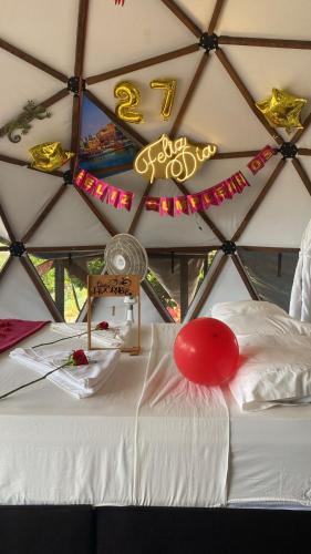 a room with a white bed with a red balloon on it at Eco-Glamping Shalom in Mariquita