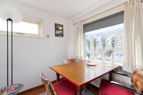a dining room with a wooden table and a window at Authentic Dutch Houseboat in Amsterdam Zuid in Amsterdam