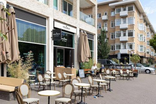 a group of tables and chairs in front of a building at Authentic Dutch Houseboat in Amsterdam Zuid in Amsterdam