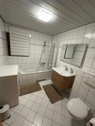 a bathroom with a sink and a tub and a toilet at Apartment Dobias in Kelberg