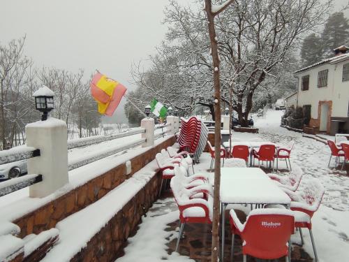 a group of tables and chairs covered in snow at Dulce Posada in Cazorla