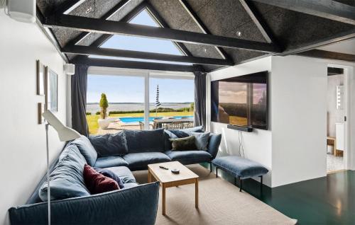 a living room with a blue couch and a table at Lovely Home In Skibby With Sauna in Skibby