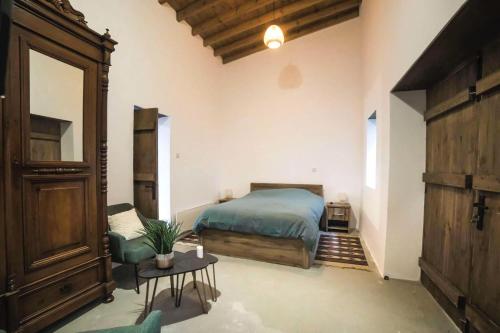 a bedroom with a bed and a chair and a table at Eftychia's House in Lofou