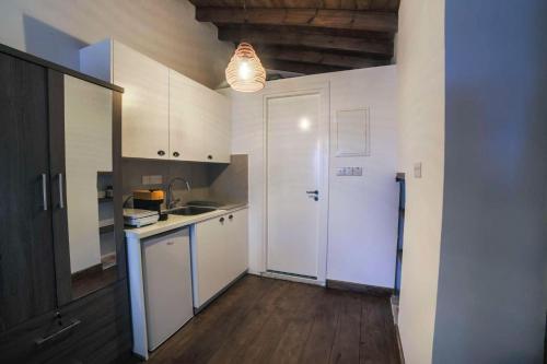 a kitchen with white cabinets and a sink at Eftychia's House in Lofou