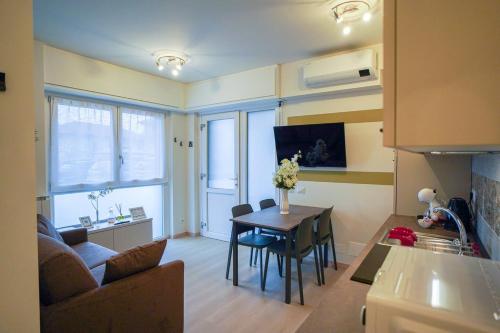 a kitchen and living room with a table and a couch at Gelsomino Suite Leonardo Academy, MXP & Laghi in Sesto Calende