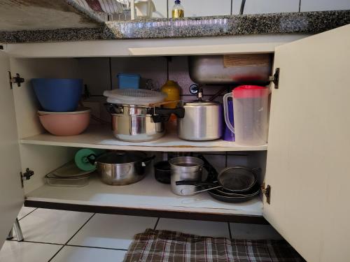 a shelf with pots and pans and other kitchen items at Flat 203 Ed Clarice Lispector, Ilhotas- Rio Poty in Teresina