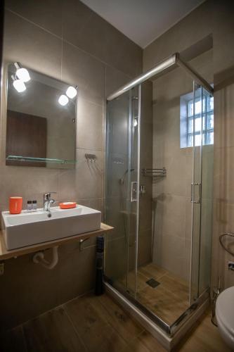 a bathroom with a glass shower and a sink at Ξαπόσταμα XAPOSTAMA - Ενοικιαζόμενα Δωμάτια in Kalyvia