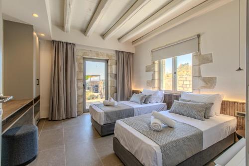 two beds in a hotel room with a window at Villa Lefkothea in Georgioupoli