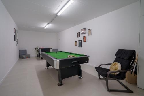 a room with a pool table and a chair at Villa Gold with ocean view, jacuzzi and private pool in Ribamar