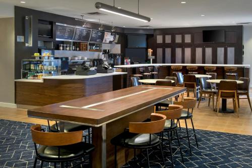a restaurant with a bar with tables and chairs at Courtyard by Marriott Basking Ridge in Basking Ridge