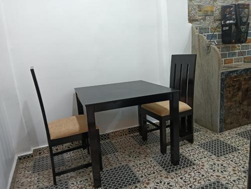a black table and two chairs in a room at White Guest House in Candolim