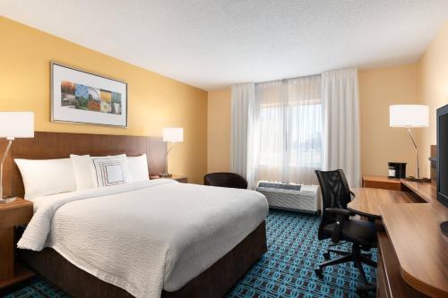 a hotel room with a bed and a desk and a window at Fairfield Inn by Marriott Deptford in Deptford