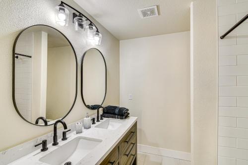 a bathroom with two sinks and a large mirror at 1 Mi to Pioneer Crossing Casino Fernley Retreat! in Fernley
