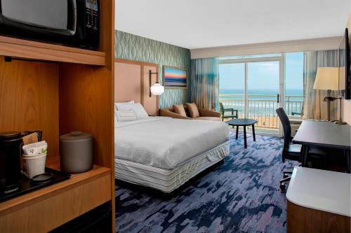a hotel room with a bed and a balcony at Fairfield Inn & Suites by Marriott Virginia Beach Oceanfront in Virginia Beach