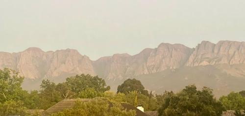 a view of a mountain range with trees and buildings at Serenity Suite in Somerset West