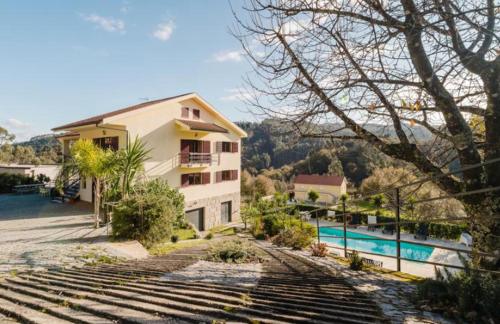 a house with a swimming pool next to a building at Alojamento Casa da Pedra Verde in Vieira do Minho