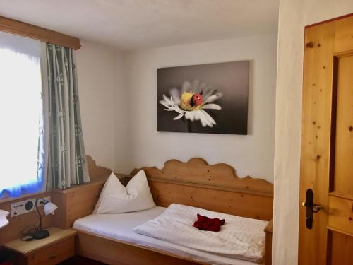 a bedroom with a bed with a flower on the wall at Hotel Metzgerwirt in Kirchberg in Tirol