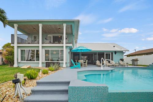 a house with a swimming pool in front of a house at Infinity & Beyond Lake Front in Cape Coral
