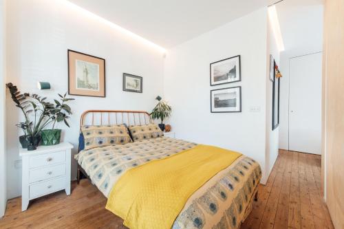 a bedroom with a bed with a yellow blanket at Stylish 2 Bedroom Flat with a Private Sauna in Finchley