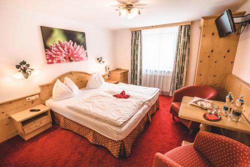 a hotel room with a bed and a table at Hotel Metzgerwirt in Kirchberg in Tirol