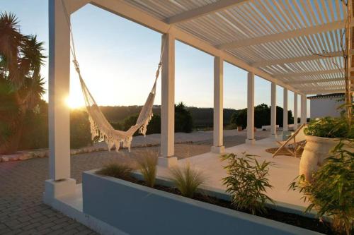 a patio with a hammock on a building at Herdade d' Amoreira Lavanda Villa in Aljezur