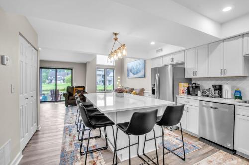 a kitchen with a white counter and chairs in it at Family townhouse with Fireplace in Ellicottville