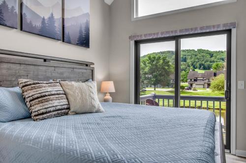a bedroom with a bed and a large window at Family townhouse with Fireplace in Ellicottville