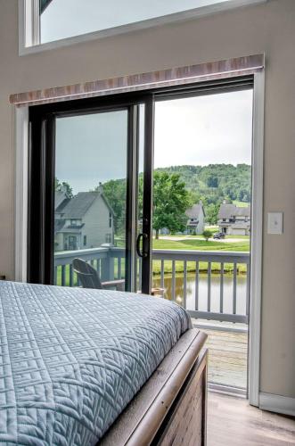 a bedroom with a bed and a balcony with a view at Family townhouse with Fireplace in Ellicottville