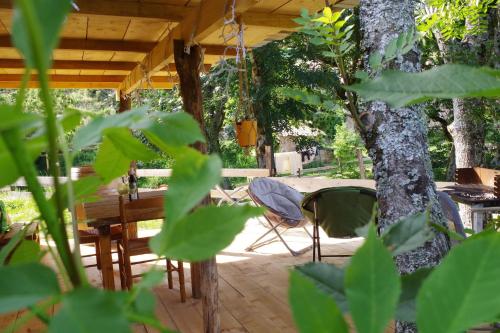 une terrasse avec une table et une chaise sous un arbre dans l'établissement Ferme de Samson, à Saint-Péray