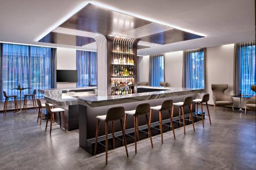 a bar in a room with chairs and tables at AC Hotel by Marriott Grand Rapids Downtown in Grand Rapids