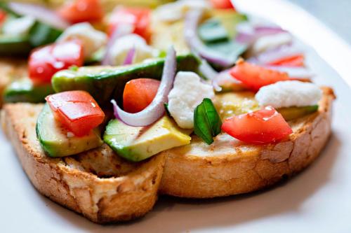 a piece of bread with vegetables on it on a plate at AC Hotel by Marriott Grand Rapids Downtown in Grand Rapids