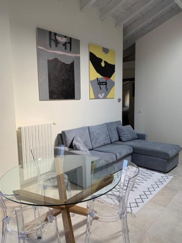 a living room with a blue couch and a glass table at Garda Girasole trilocale a due passi dal lago con posto auto privato in Desenzano del Garda