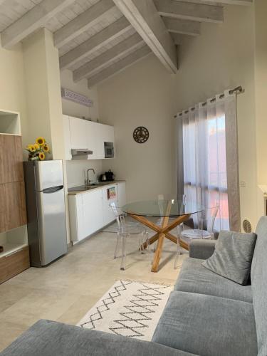 a living room with a couch and a table at Garda Girasole trilocale a due passi dal lago con posto auto privato in Desenzano del Garda