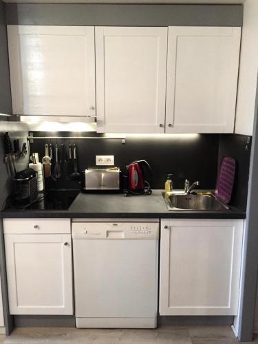 une cuisine avec des armoires blanches et un évier dans l'établissement Résidence L'Ours Blanc - maeva Home - Appartement 3 pièces 6 personnes - Exclusive - super Home MAE-5741, à Huez
