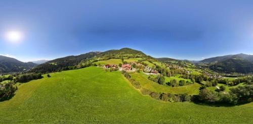 an aerial view of a green hill with a house on it at Zlattinger in Trebesing