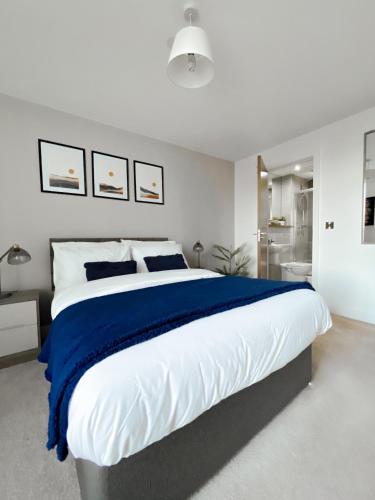a bedroom with a large bed with blue and white sheets at The Panda - Modern 2 Bedroom Apt in Manchester City Centre in Manchester