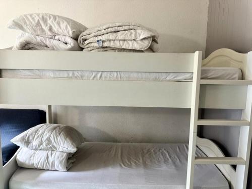 - 2 lits superposés avec des draps et des oreillers blancs dans l'établissement Résidence Le Tourmalet - maeva Home - Studio 4 personnes - Confort MAE-8071, à La Mongie