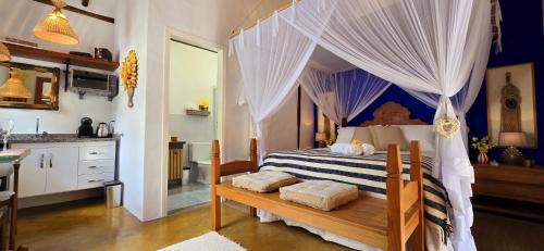 a bedroom with a bed with a canopy at Suíte Kuta - Buddha House in Ilhabela