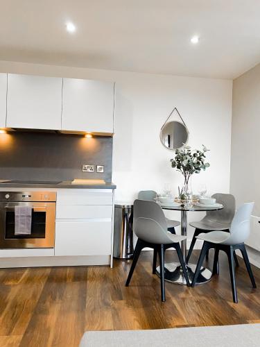 a kitchen and dining room with a table and chairs at The Panda - Modern 2 Bedroom Apt in Manchester City Centre in Manchester